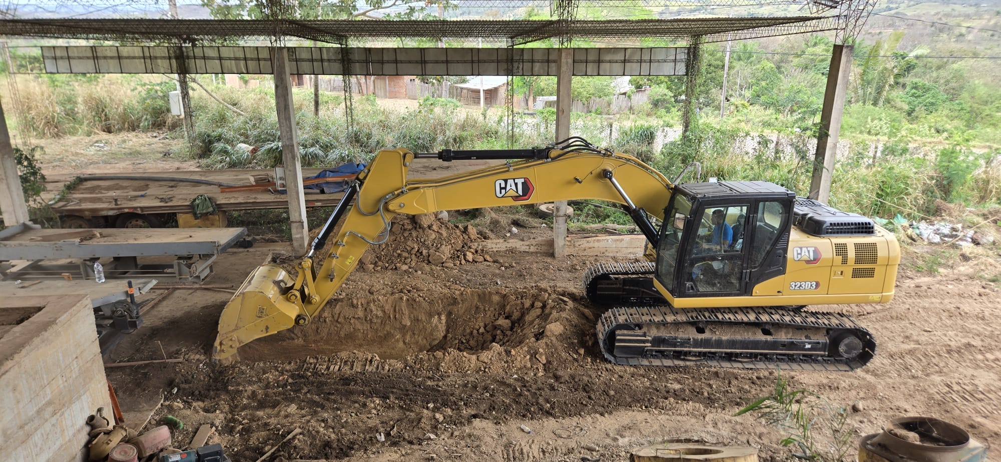 Excavator and material handling equipment at a covered project site